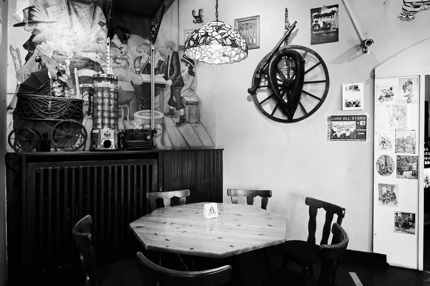 Ein rustikales Café-Interieur ist mit historischen Gegenständen und einer gemalten Wanddekoration ausgestattet.