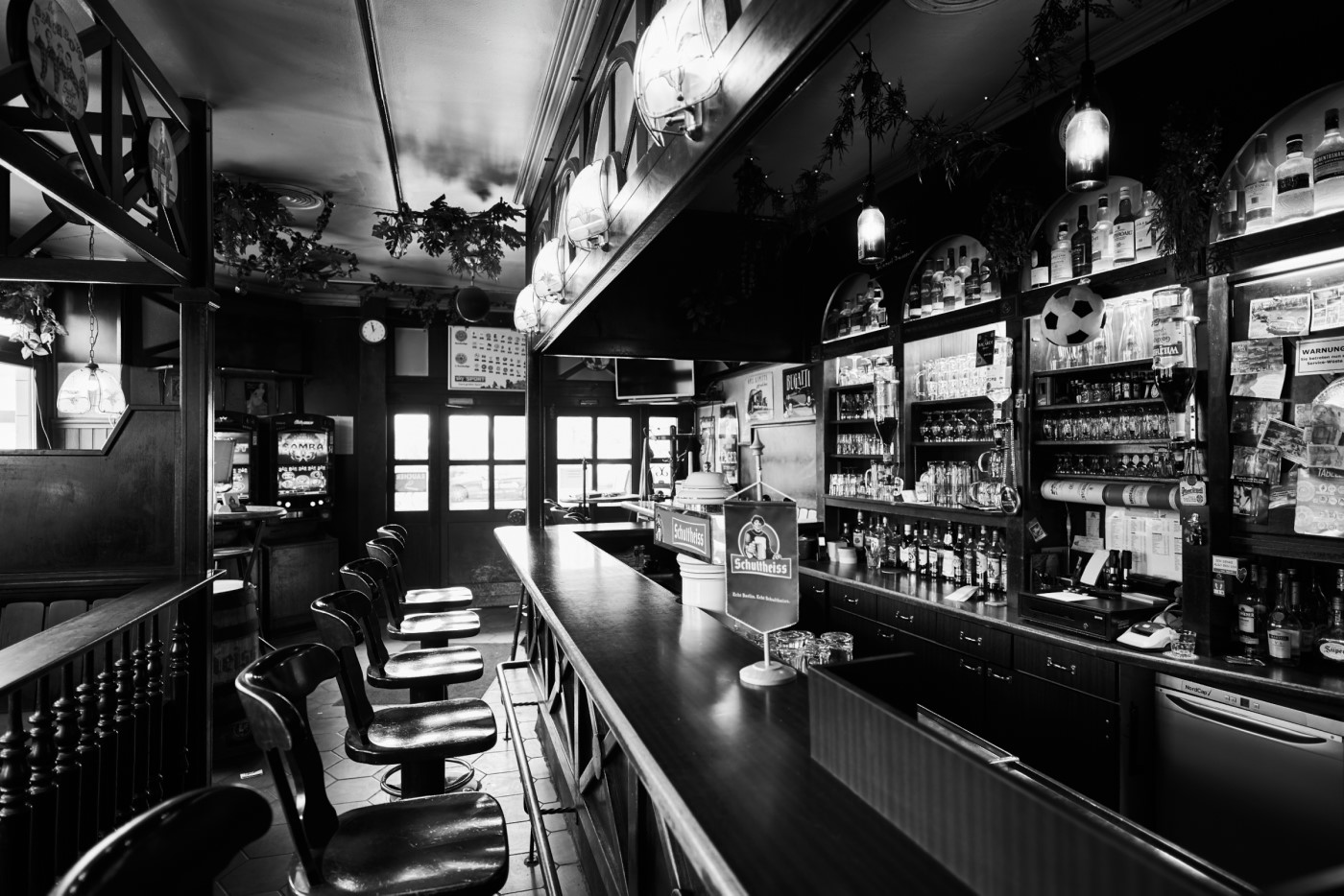 Innenansicht einer verlassenen Bar mit Sitzhockern und einer Getränketheke.